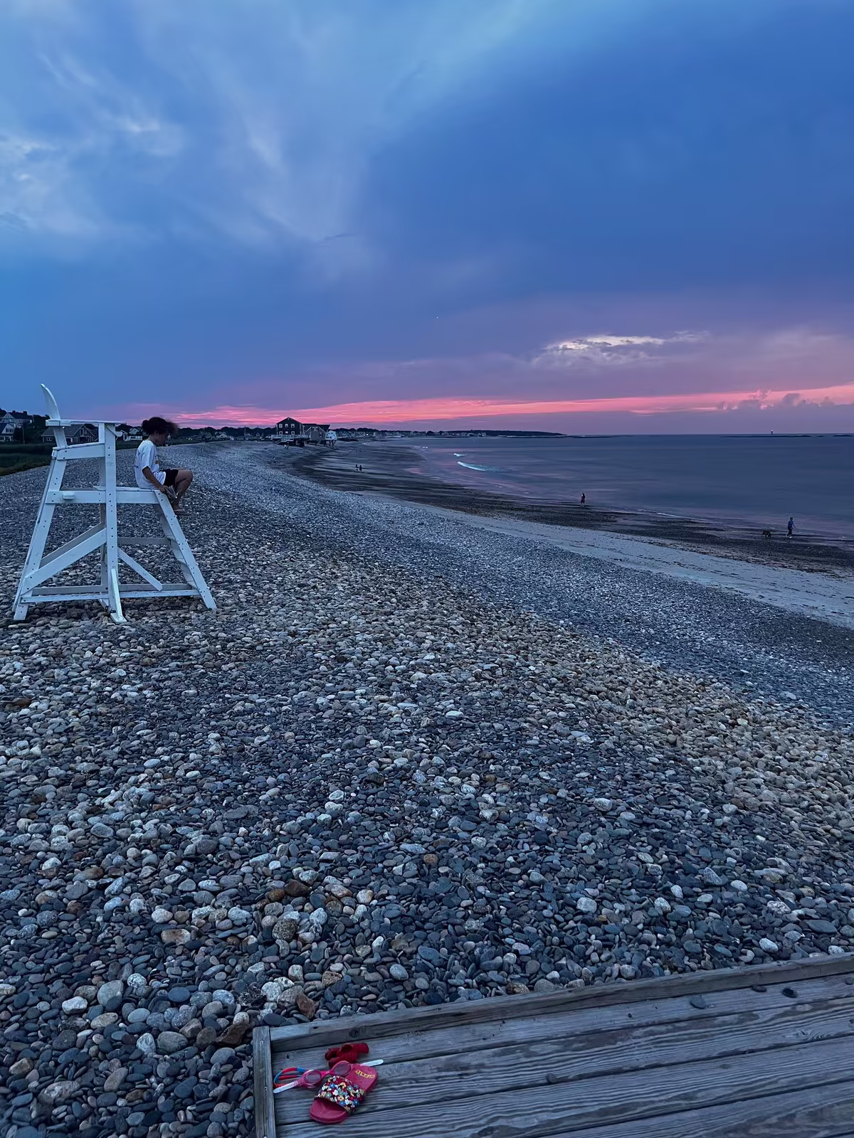 The beach at pink dusk, the lifeguard chair watching the empty shore